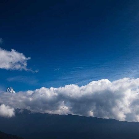 Der blaue Himmel mit Wolkenformationen hinter einer Bergkette