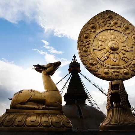 Goldene Statuen eines Rehs und einer stark verzierten spitz zulaufenden Scheibe