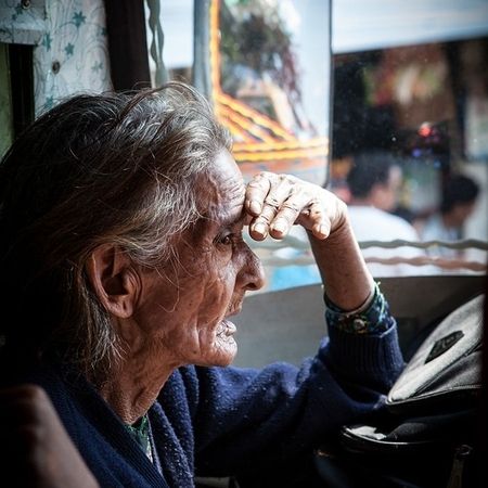 Eine ältere Frau sitzt in einem Fahrzeug nahe einem Fenster