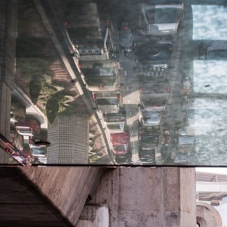 Spiegelung einer dicht befahrenen Straße an einer Holzkonstruktion